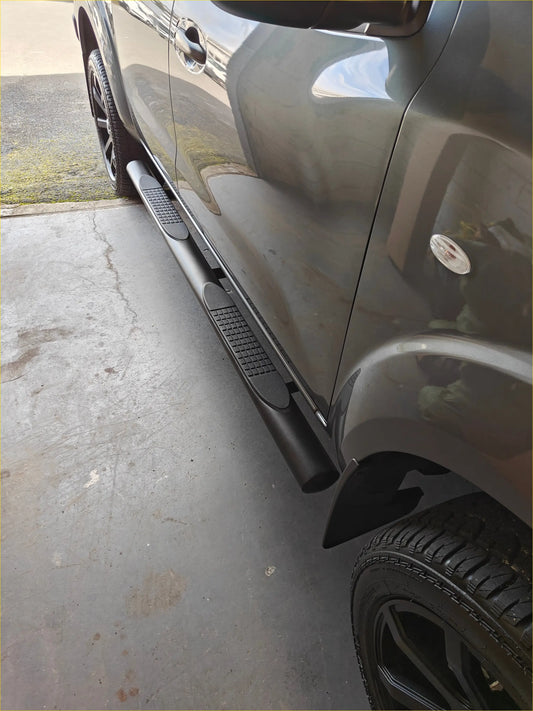 Black stainless steel 4‑inch oval tube running board textured side step on dark gray hilux pickup lower edge