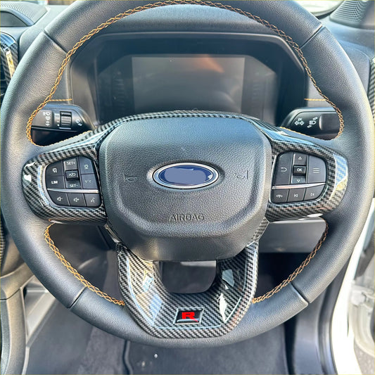 Black leather steering wheel with carbon fiber trim and gold stitching featuring ford logo for ranger 2022 plus