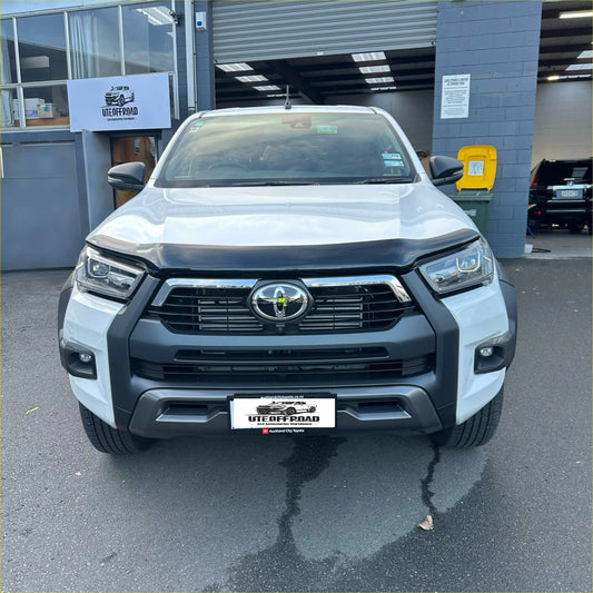 White toyota hilux 2021-2025 with black monsoon bonnet guard and chrome grille front bumper guard