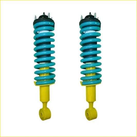 A pair of vibrant teal and yellow coil-over shock absorbers with black mounts for nissan pathfinder r51 diesel tdi