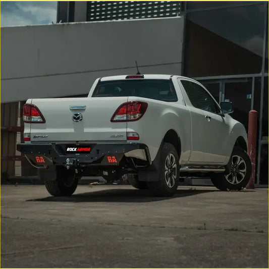 Back view of white mazda bt-50 with black rockarmor elite steel rear step and red logo accents from 2011-2020 model