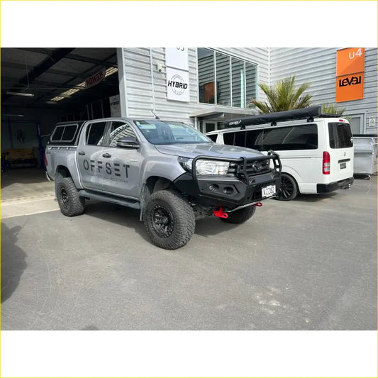 Silver toyota hilux with black steel rockarmor gt hoop bullbar and offset branding for off-road use