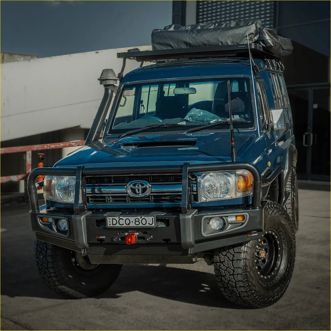 Deep blue toyota land cruiser with rockarmor premium steel bullbar rugged off-road tires and roof rack gear