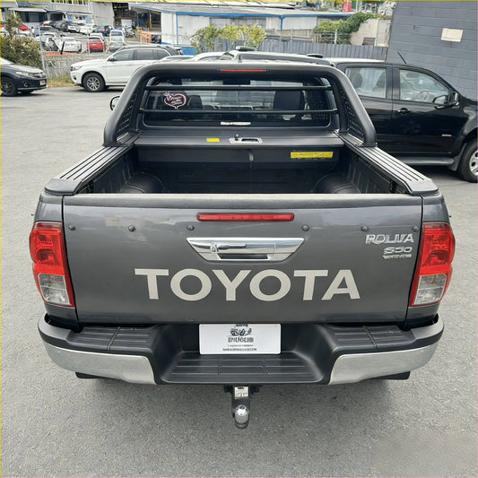 Back of gray toyota hilux rollya s50 pickup with black bed liner and chrome accents featuring roll bar t10 and manual roller shutter