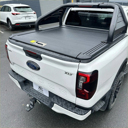 Black retractable textured tonneau cover with integrated handle on white ford ranger xlt back side roll bar t20 manual shutter