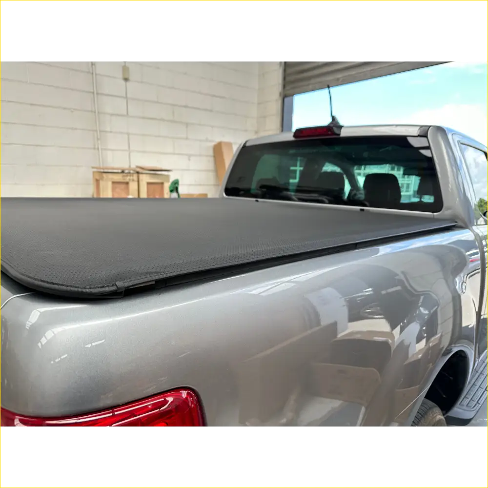 Black fabric tonneau cover on the back of a silver Volkswagen Amarok pickup truck bed for NZ 2026 accessories guide