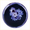 A 15cm purple blue hana gear knob featuring a circular glass dish with delicate purple and white flowers floating in dark liquid