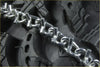 Shiny metallic 2 x raider front tire chains v-bar with interlocking links on rugged black suzuki quadrunner 250 tire