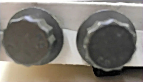 Two dark gray hexagonal headed bolts with textured surface for challenger l200 triton 25 td hole head gasket kit