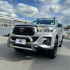 Silver Toyota Hilux with 304 stainless steel medium size nudge bar, chrome bull bar, and black roof rack, front view