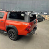 Black metal roof rack mounted on red pickup truck with aluminium canopy carport cover for toyota hilux 2015-2025 sr5 back view
