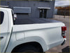 Black aluminium tri fold hardlid tonneau cover on white triton 2015+ pickup truck shown from the back side