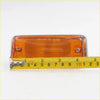Amber side marker light for nissan datsun 620 1972-1979 with orange led, chrome bezel, and two mounting screws shown next to tape