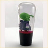 A green alien-like figurine dressed in purple inside a clear glass cylinder with red liquid ball z piccolo kid gear knob clear