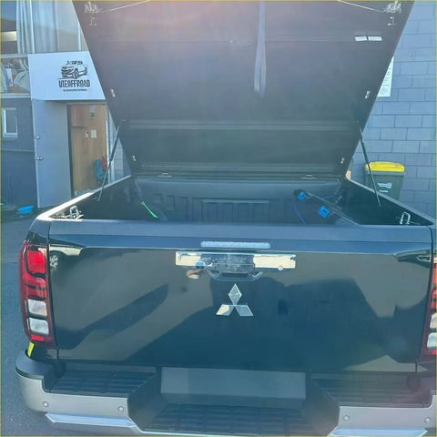 Black mitsubishi triton 2024+ bedside rail covers 3 piece set shown from back with lifted tailgate and open bed