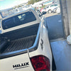 White toyota hilux sr5 cruiser pickup with black trim and 4x4 badging showing textured black bedside rail covers set