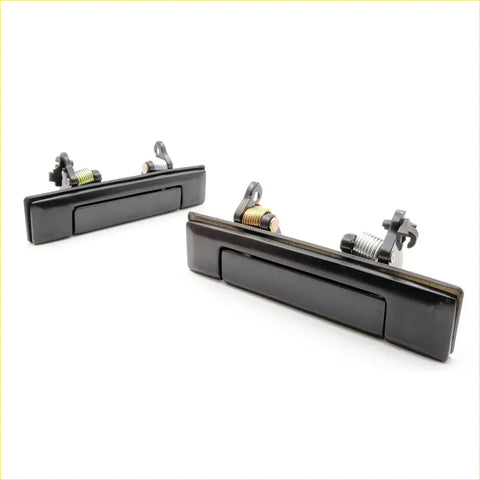 Black plastic car door handles x2 with metallic springs shown from back for toyota hilux ute 1984-1988