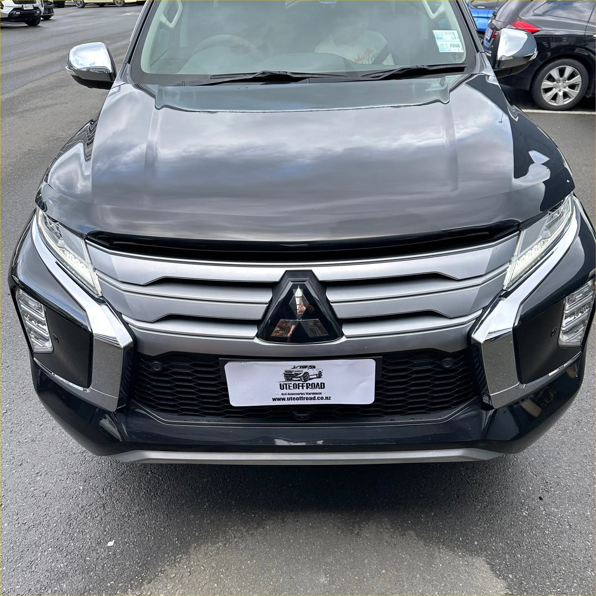 Black bonnet guard protector stone guard on mitsubishi triton suv with sleek grille and sharp led headlights