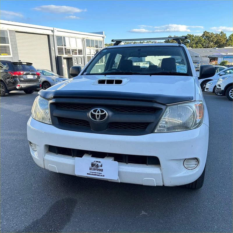 White toyota hilux pickup with black grille and roof rack featuring matte black bonnet guard protector stone guard