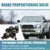 Black brake proportioning valve with metallic fittings and threaded stem shown next to silver toyota tacoma truck