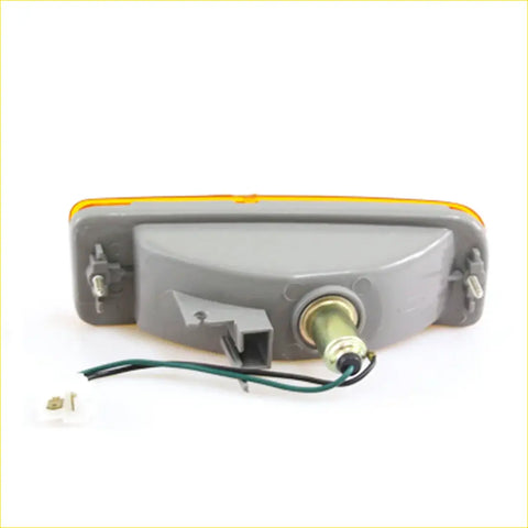 Gray plastic bumper turn signal light with yellow lens and exposed wiring for toyota hilux 1988-1997 back side view