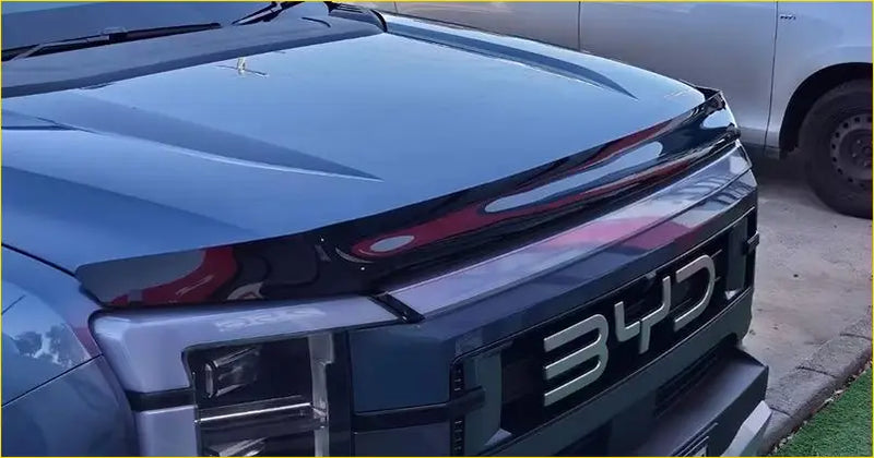 Dark blue byd truck with sleek modern front grille and red accent lighting featuring the byd shark 2025+ bonnet guard