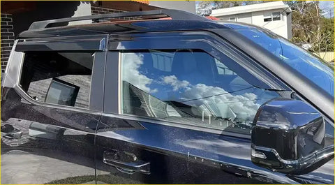 Black suv with sleek glossy finish and roof rack showcasing BYD shark 2025 window visors from the back side