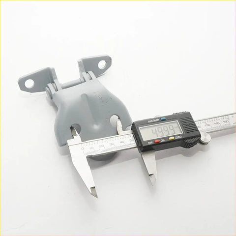 Gray plastic door hinge with two mounting flanges and central pivot measured by caliper for mitsubishi pajero sport