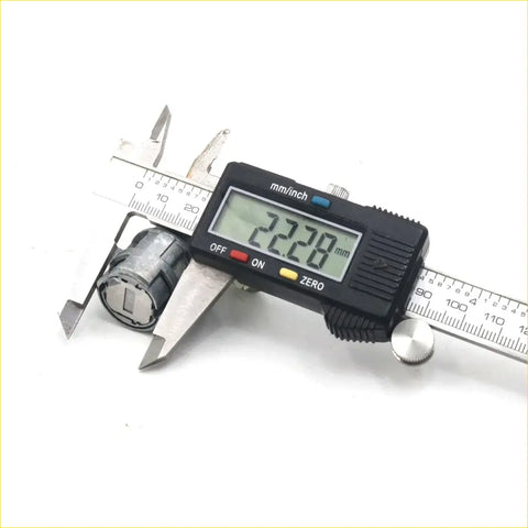 A black digital caliper with a silver metal body measuring a door lock cylinder for toyota hilux 1988-1997