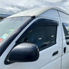 Black carbon fiber textured door visor installed on white toyota hiace van for weather protection 2005-2019