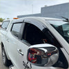 Black plastic door visors weather shields installed on white mitsubishi triton pickup truck windows