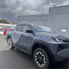 Dark gray metallic toyota hilux pickup truck with black alloy wheels and door visors window monsoons weather shields