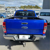 Vibrant blue ford ranger pickup with black electric roller tonneau cover and chrome accents shown from the back side