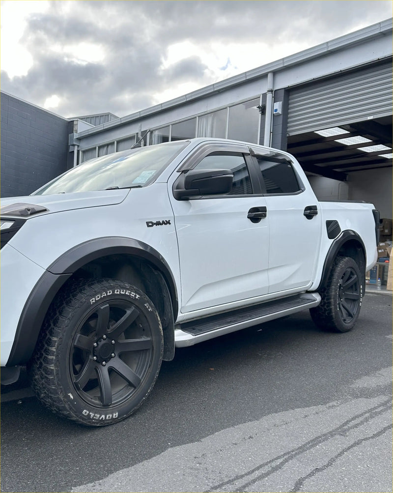 White d-max pickup truck showing rear with matte black 4-inch fender flares black wheels and side steps
