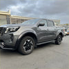 Gray metallic nissan navara pickup with matte black 4-inch fender flares black alloy wheels and side steps