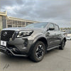 Gray metallic nissan navara pickup with 4-inch matte black fender flare and rugged front bumper with black alloy wheels