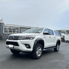 White toyota hilux pickup truck with black side steps showing lychee texture bolt style fender flare for 2015-2017 models