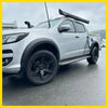 Silver chevrolet colorado with matte black smooth style fender flares black wheels and roof rack carrying kayak