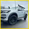 Silver chevrolet colorado with matte black smooth style fender flares black wheels roof rack and atx roll-up canopy