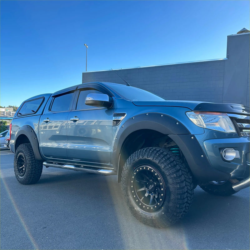 Dark blue metallic ford ranger with black lychee texture bolt style fender flares and rugged off-road tires