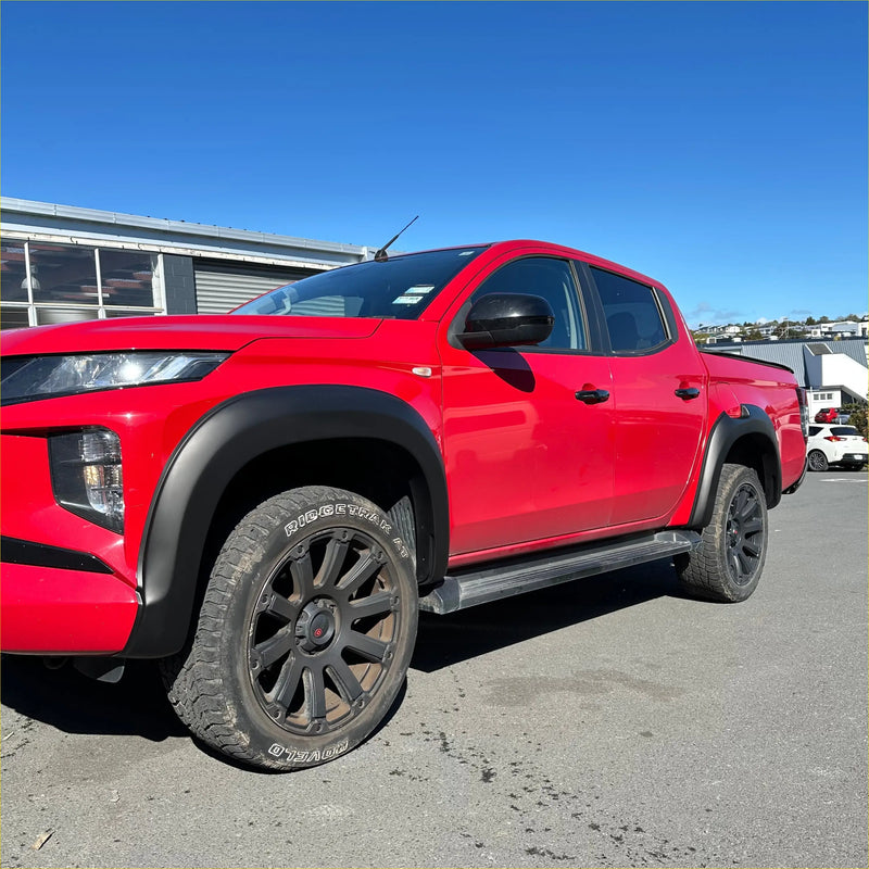 Vibrant red mitsubishi triton 2019-2023 with smooth style matte black fender flares and rugged off-road tires