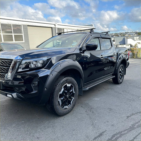 Black nissan navara pickup with matte black bolt style fender flare black alloy wheels and roof rack