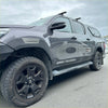 Dark gray metallic toyota hilux with black wheels and sas cruiser decals featuring grey layer oem style fender flares
