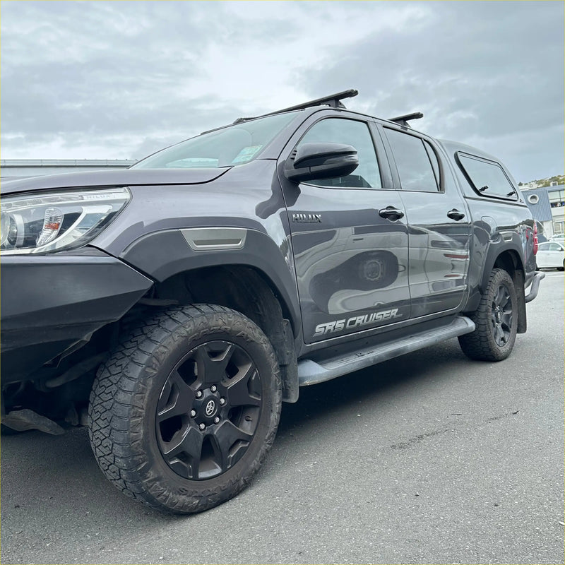 Dark gray toyota hilux sr5 cruiser with black wheels and off-road tires featuring grey layer fender flares 2015-2020