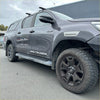 Gray metallic toyota hilux with black wheels and rugged off-road tires featuring fender flare oem style grey layer surface