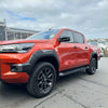 Vibrant orange Toyota Hilux 2021 2024 SR5 Cruiser with grey OEM style fender flares and rugged off-road tires
