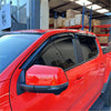 Black plastic door visors weather shield set installed on a red 2022 ford ranger pickup truck front side