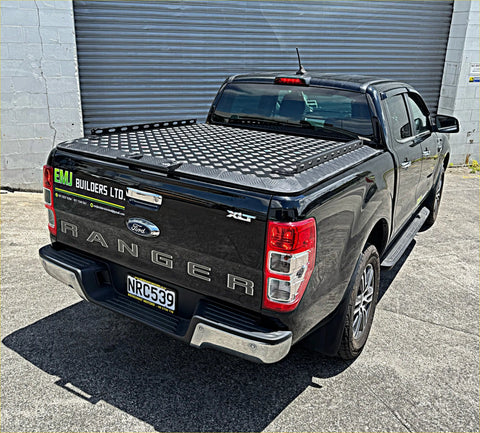 Black ford ranger xlt pickup truck backside with textured diamond-patterned aluminum hardlid bed cover