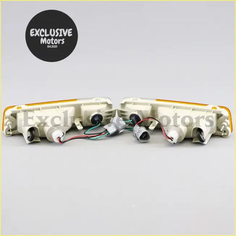 A pair of off-white plastic front bumper indicators with amber lenses and wiring for mitsubishi triton ute