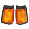 Pair of black-framed amber corner front signal lights with ribbed lens and screws for Nissan Datsun 720 Ute 1980-1989